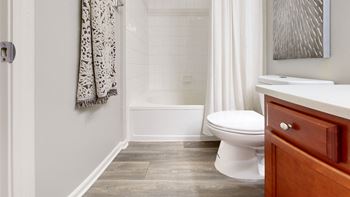 A bathroom with a toilet and a tub and a sink